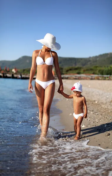 Madre e figlia a piedi lungo la spiaggia. — Foto Stock