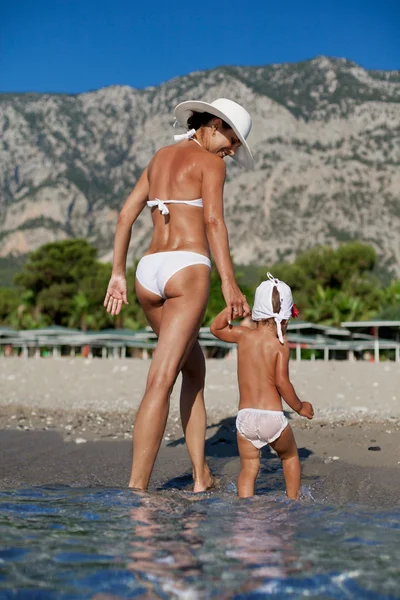 Matka a dcera kráčející po pláži. — Stock fotografie