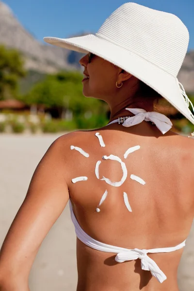 Bräunungslotion in Form von Sonne auf der Schulter der Frau. — Stockfoto