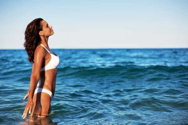Jonge vrouw genieten van de rust van de zomer aan de kust. — Stockfoto