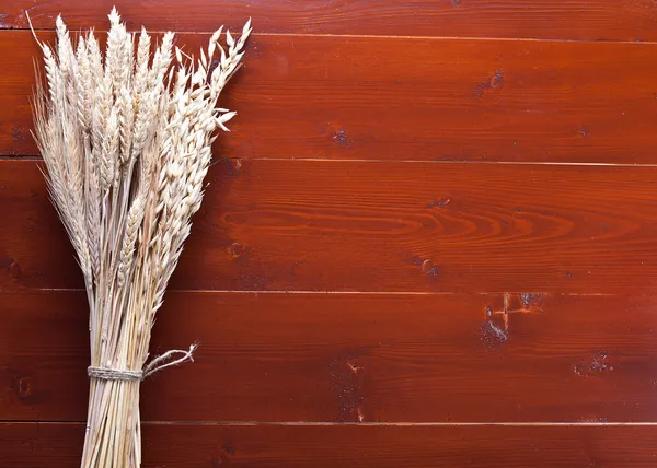 Oreilles de blé sur une vieille table en bois . — Photo