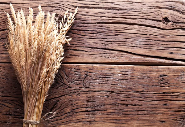 Oren van tarwe op oude houten tafel. — Stockfoto