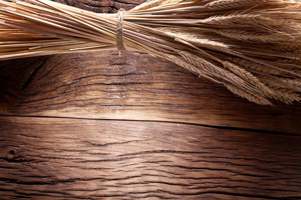 Уши пшеницы на старом деревянном столе . — стоковое фото