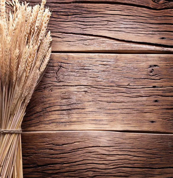 Oreilles de blé sur une vieille table en bois . — Photo