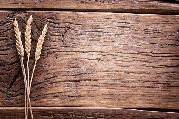 Ears of wheat on old wooden table. — Stock Photo, Image