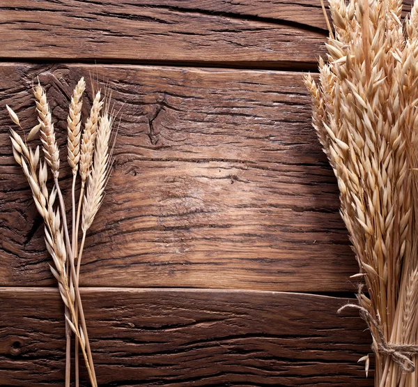 Orejas de trigo sobre una vieja mesa de madera . — Foto de Stock