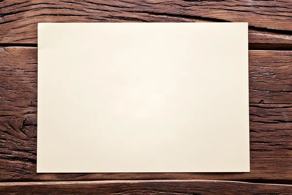 Hoja blanca de papel sobre mesa de madera vieja . —  Fotos de Stock