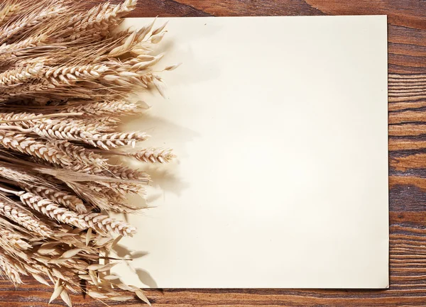 Ears of wheat on old wooden table. — Stock Photo, Image