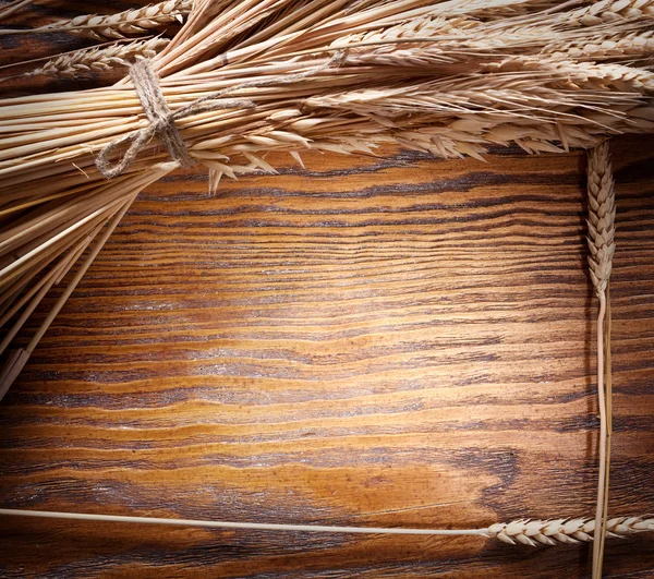 Orecchie di grano su vecchio tavolo di legno . — Foto Stock