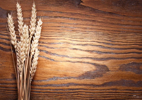 Ears of wheat on old wooden table.