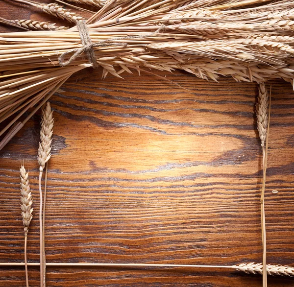 Ears of wheat on old wooden table. — Stock Photo, Image