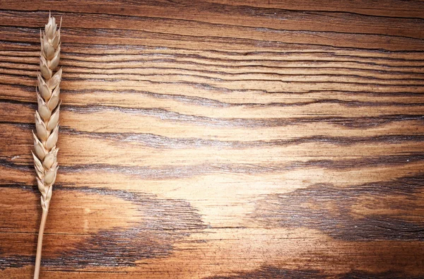 Ear of wheat on old wooden table. — Stock Photo, Image