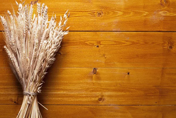 Orecchie di grano su vecchio tavolo di legno . — Foto Stock