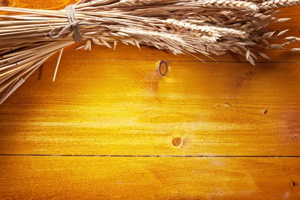 Kłosy pszenicy na starym drewnianym stole. — Zdjęcie stockowe