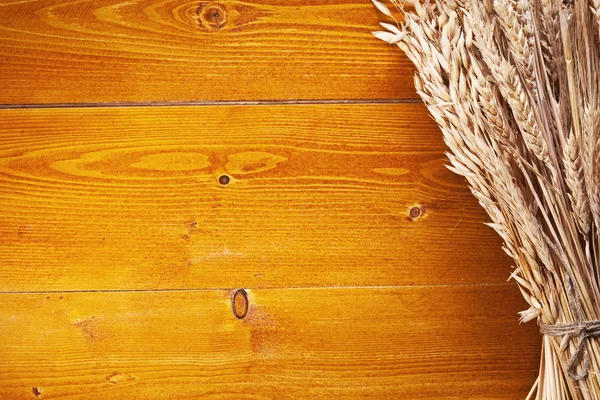 Uši pšenice na starý dřevěný stůl. — Stock fotografie