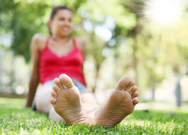 Junge Frau auf dem Gras. das Gesicht im Defokus. — Stockfoto