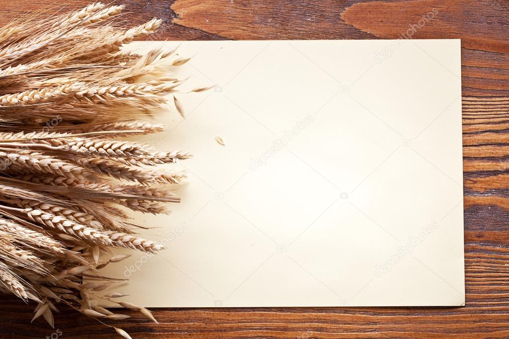 Ears of wheat on old wooden table.