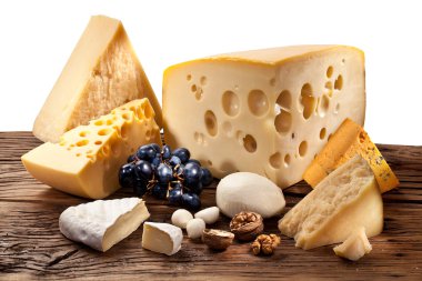 Different types of cheese over old wooden table. clipart