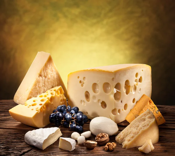 Different types of cheese over old wooden table. — Stock Photo, Image