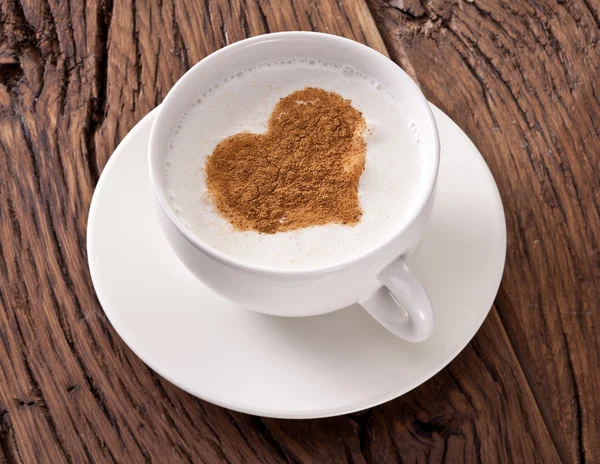 Tazza di cappuccino con cannella macinata a forma di cuore . — Foto Stock