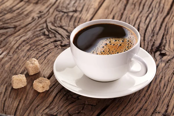 Xícara de café na velha mesa de madeira . — Fotografia de Stock