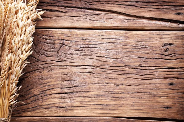 Orejas de trigo sobre una vieja mesa de madera . — Foto de Stock