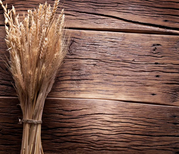 Orecchie di grano su vecchio tavolo di legno . — Foto Stock