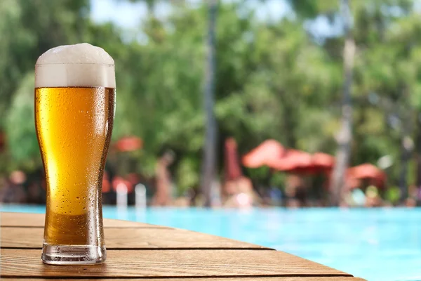 Cold beer glass on the bar table at the open-air cafe. — Stock Photo, Image