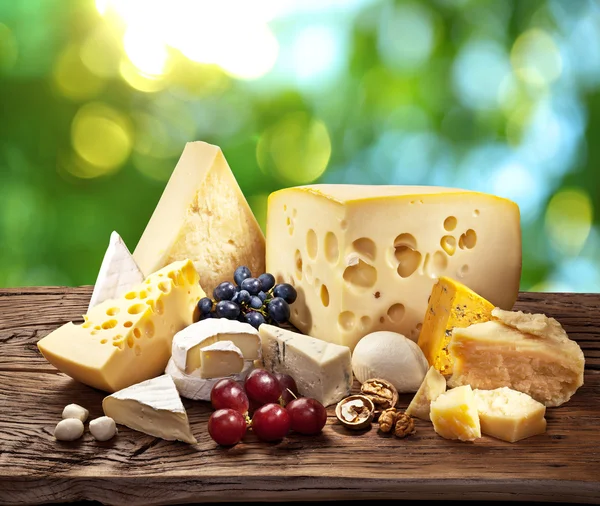 Verschillende soorten kaas over oude houten tafel. — Stockfoto