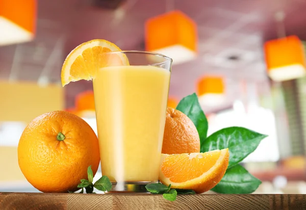 Orangenfrüchte und ein Glas Orangensaft. — Stockfoto