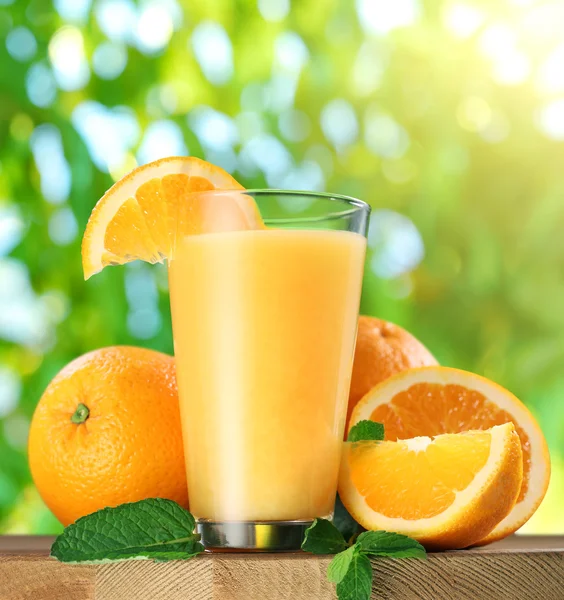 Orangenfrüchte und ein Glas Orangensaft. — Stockfoto