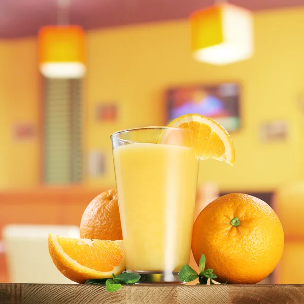 Orange frukter och glas apelsinjuice. — Stockfoto