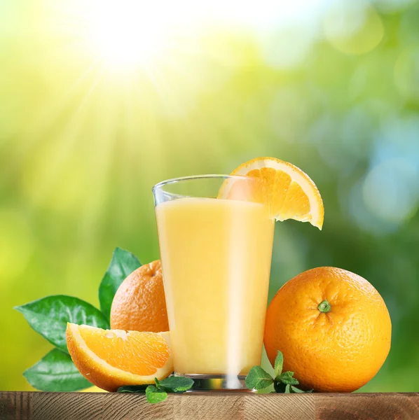 Turuncu meyveler ve bardak portakal suyu. — Stok fotoğraf
