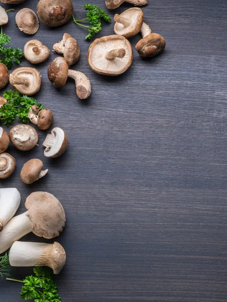 Cogumelos Comestíveis Cor Marrom Diferente Mesa Preta Com Ervas Vista — Fotografia de Stock