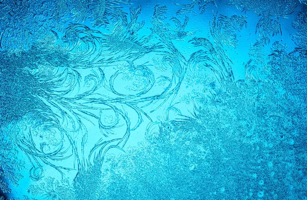 クリスマスの不思議のシンボルとして冷凍ウィンドウ上の美しい青霜パターン クリスマスや新年の背景 — ストック写真