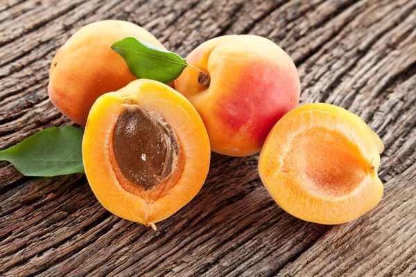 Frutas Maduras Albaricoque Con Rodajas Hojas Albaricoque Una Mesa Madera — Foto de Stock