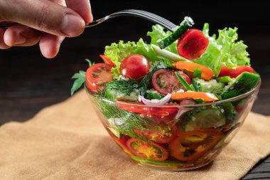 Sebze salatası ve cam yapraklı sebze yağı ahşap masanın üstünde..