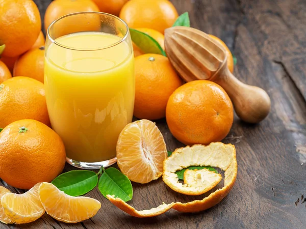 Orangefarbene Mandarinenfrüchte Und Ein Glas Frischer Mandarinensaft Auf Dunklem Holzgrund — Stockfoto