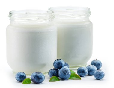 Beyaz arka planda sade yoğurt ve meyveli iki cam kap..