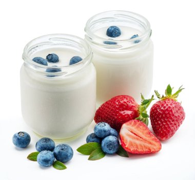 Beyaz arka planda sade yoğurt ve meyveli iki cam kap..