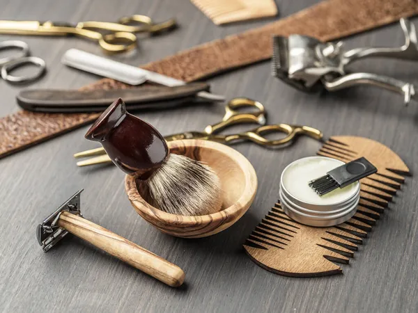 Classic grooming and hairdressing tools on wooden background. Top view on barbershop instruments  laying on dark wooden table.