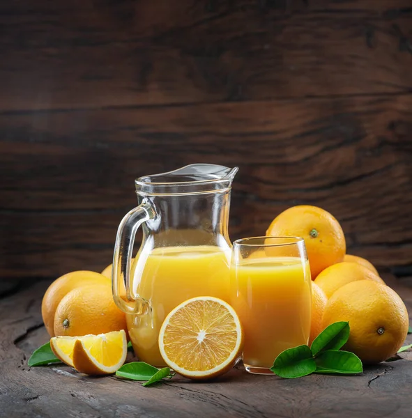 Gelbe Orangenfrüchte Und Frischer Orangensaft Isoliert Auf Dunklem Holzgrund — Stockfoto