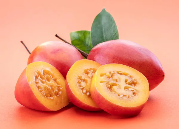 Ripe Tamarillo Fruits Slices Tamarillo Leaves Isolated Orange Background — Stock Photo, Image