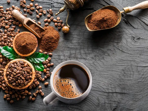 木製のテーブルの上で焙煎されたコーヒー豆 コーヒーカップ グランドコーヒー トップ表示 — ストック写真