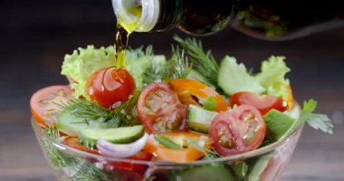 Zeytinyağıyla doldurulmuş siyah bir zemin üzerinde cam bir kasede taze sebze salatası. Blackmagic Ursa Pro G2, 4K, 150 fps.