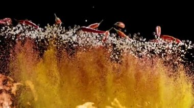 Baharat karışımı, çeşitli biber, tuz ve küçük kırmızı biber karışımı yavaşça yükselir ve siyah arka plana düşer. 300fps