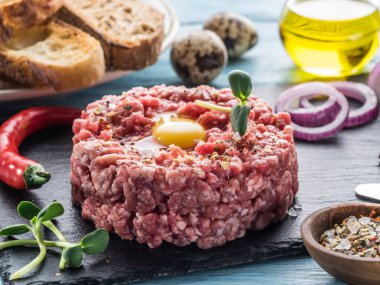 Biftek tartar ve yumurta sarısı. Gri tahtada. Yakın plan..