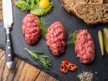 Biftek tartar, yumurta sarısı, ekmek ve salatalık turşusu..