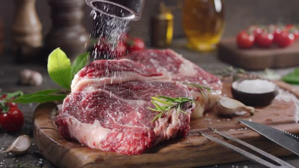 Twee Rauwe Rib Oogsteaks Met Specerijen Kruiden Een Houten Keukentafel — Stockvideo