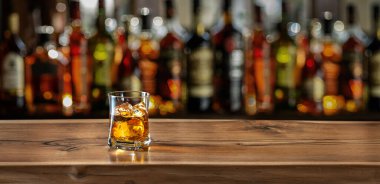 Glass of whiskey on the bar counter. Blurred interior of bar at the background. clipart